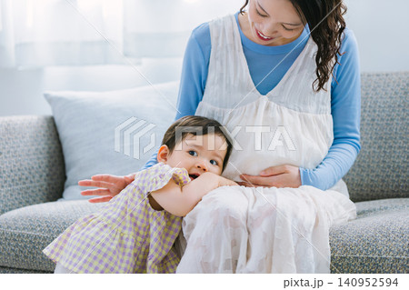 リビングで妊婦のお母さんに甘える女の子 リビングで妊婦のお母さんに甘える女の子 140952594