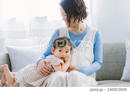 リビングで妊婦のお母さんに甘える女の子 リビングで妊婦のお母さんに甘える女の子 140952600