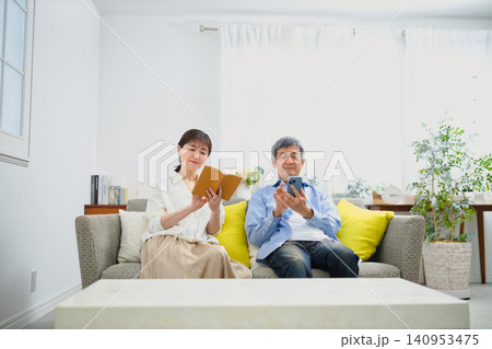 ソファーに座ってリラックスして過ごすシニアの夫婦 ソファーに座ってリラックスして過ごすシニアの夫婦 140953475