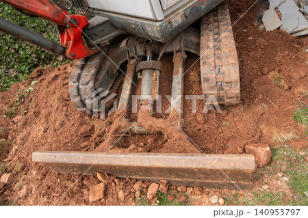 A close-up shot of excavator tracks and the heavy counterweight, showcasing the robust construction of the machinery. The intricate details highlight the power and durability of the equipment in A close-up shot of excavator tracks and the heavy counterweight, showcasing the robust construction of the machinery. The intricate details highlight the power and durability of the equipment in 140953797
