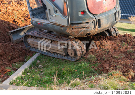 Close-up of excavator tracks heavy down and heavy counterweight, showing the solid construction of the machinery Close-up of excavator tracks heavy down and heavy counterweight, showing the solid construction of the machinery 140953821