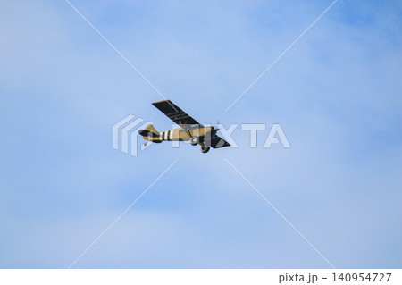 One Vintage Propeller Aircraft Flying in the Sky on a Clear Day One Vintage Propeller Aircraft Flying in the Sky on a Clear Day 140954727