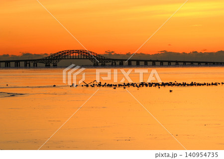 Orange reflection on Frozen Great South Bay at Sunrise With Bridge Near Babylon Orange reflection on Frozen Great South Bay at Sunrise With Bridge Near Babylon 140954735