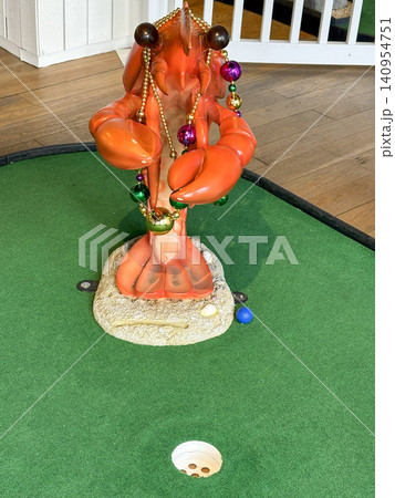 Lobster Statue With Decorations Near an Indoor Mini Golf Hole Lobster Statue With Decorations Near an Indoor Mini Golf Hole 140954751