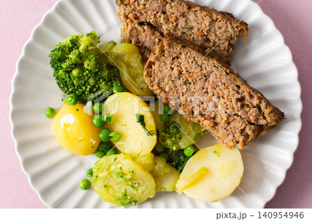 A plate of boiled potatoes, turkey meat pie, broccoli, and green peas is ready for breakfast. This meal is healthy and offers a good start to the day with nutritious ingredients A plate of boiled potatoes, turkey meat pie, broccoli, and green peas is ready for breakfast. This meal is healthy and offers a good start to the day with nutritious ingredients 140954946