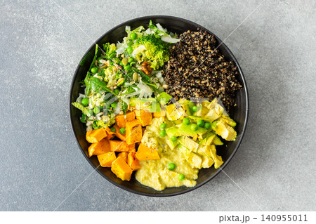 A bowl filled with quinoa, roasted pumpkin, hummus, and a salad of fresh avocado is ready to eat. This meal is gluten free and offers a healthy start to the day A bowl filled with quinoa, roasted pumpkin, hummus, and a salad of fresh avocado is ready to eat. This meal is gluten free and offers a healthy start to the day 140955011