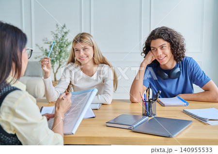 Smiling teenage students listening to female teacher 140955533