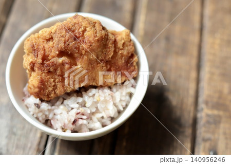 ご飯の上に乗せたカリッとジューシーな鶏もも肉の大きな唐揚げ ご飯の上に乗せたカリッとジューシーな鶏もも肉の大きな唐揚げ 140956246