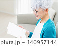 ソファに座って本を読むシニア女性 140957144