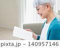 ソファに座って本を読むシニア女性 140957146