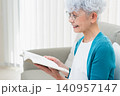 ソファに座って本を読むシニア女性 140957147