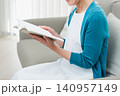ソファに座って本を読むシニア女性 140957149
