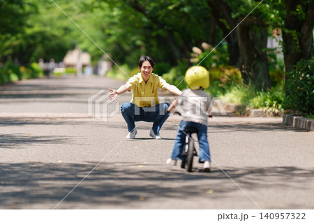 キックバイクに乗る2歳の男の子を見守る父親 140957322