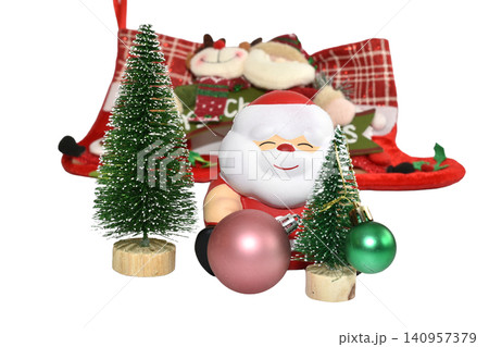 santa claus figurine holding festive ornaments and trees in a holiday-themed setting with a wooden base and colorful decorations in a bright and warm atmosphere. santa claus figurine holding festive ornaments and trees in a holiday-themed setting with a wooden base and colorful decorations in a bright and warm atmosphere. 140957379