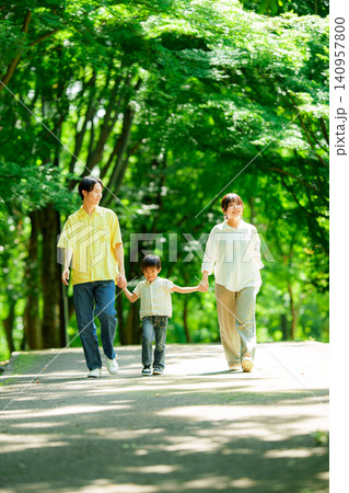 手を繋いで公園を歩く三人家族 手を繋いで公園を歩く三人家族 140957800