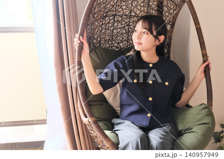 リビングのハンギングチェアでくつろぐ女性 リビングのハンギングチェアでくつろぐ女性 140957949