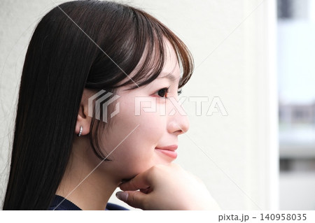 ベランダから見える景色を眺めて休憩する女性 140958035