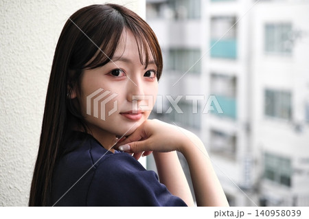 ベランダから見える景色を眺めて休憩する女性 ベランダから見える景色を眺めて休憩する女性 140958039