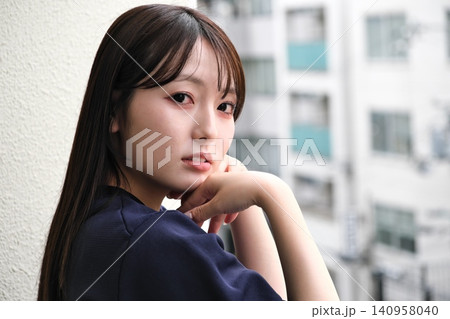 ベランダから見える景色を眺めて休憩する女性 140958040