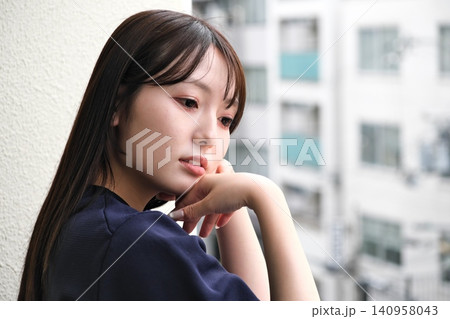 ベランダから見える景色を眺めて休憩する女性 ベランダから見える景色を眺めて休憩する女性 140958043
