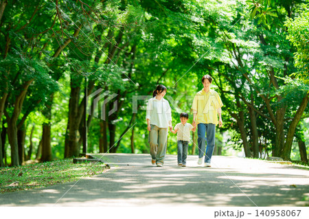 手を繋いで公園を歩く三人家族 手を繋いで公園を歩く三人家族 140958067