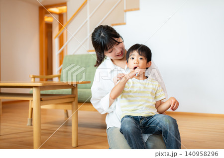 子供の歯磨きを見守る母親 子供の歯磨きを見守る母親 140958296