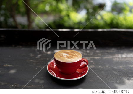 Cappuccino coffee in a red cup on black old grunge wooden table Cappuccino coffee in a red cup on black old grunge wooden table 140958797