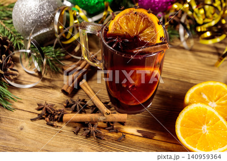 Christmas mulled wine with spices and Christmas decoration on wooden table Christmas mulled wine with spices and Christmas decoration on wooden table 140959364
