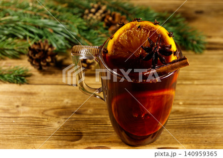 Christmas mulled wine with spices and fir tree branches and cones on wooden table Christmas mulled wine with spices and fir tree branches and cones on wooden table 140959365