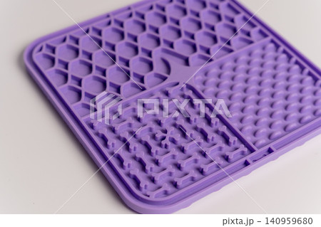 Slow feeding licking mat for dogs and cats used in home setting during play Slow feeding licking mat for dogs and cats used in home setting during play 140959680
