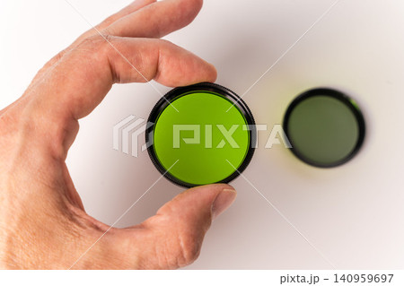 Holding a green filter for vintage movie cameras in hand Holding a green filter for vintage movie cameras in hand 140959697