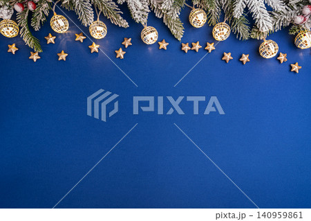 Christmas Lights and Stars with Snowy Pine on Blue Background 140959861