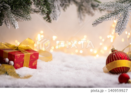 Red Gift Box with Gold Ribbon Among Christmas Decorations Red Gift Box with Gold Ribbon Among Christmas Decorations 140959927