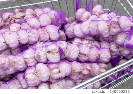 garlic bulbs in purple mesh sacks background garlic bulbs in purple mesh sacks background 140960258