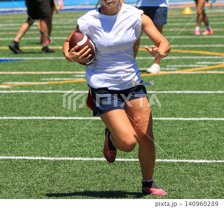 Running With a Football at a Flag Football Practice Session Running With a Football at a Flag Football Practice Session 140960289