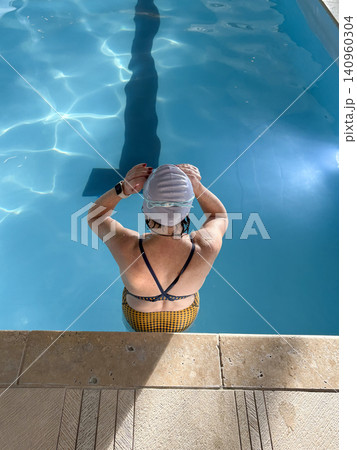Swimmer Prepares to start swimming laps In an IndoorPool for Daily Practice Session Swimmer Prepares to start swimming laps In an IndoorPool for Daily Practice Session 140960304