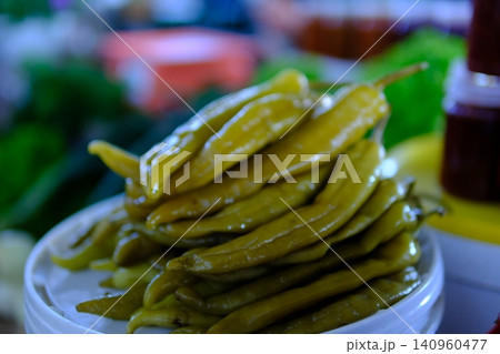 long pickled pepper, pickled chili pepper. Green chili achar in a small bowl. Tasty homemade food and cooking concept. long pickled pepper, pickled chili pepper. Green chili achar in a small bowl. Tasty homemade food and cooking concept. 140960477