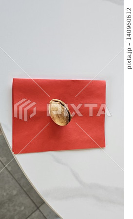Traditional baked walnut shaped cookies with sweet condensed milk filling placed on red napkin in cozy homemade dessert and bakery atmosphere Traditional baked walnut shaped cookies with sweet condensed milk filling placed on red napkin in cozy homemade dessert and bakery atmosphere 140960612
