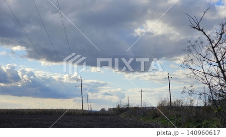 high voltage pylons crossing open field under vast sky minimal industrial landscape high voltage pylons crossing open field under vast sky minimal industrial landscape 140960617