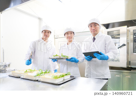 カメラ目線で笑顔を見せる食品工場の男女3名スタッフ カメラ目線で笑顔を見せる食品工場の男女3名スタッフ 140960721