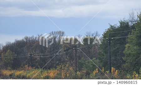 power transmission towers near forest in autumn with colorful leaves roadside view power transmission towers near forest in autumn with colorful leaves roadside view 140960815