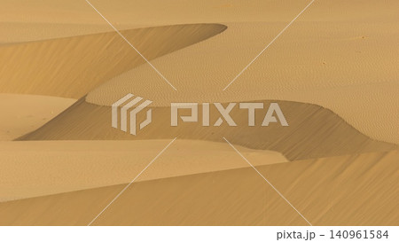 A minimalist perspective on the vast Viana desert landscape in Boa Vista, Cape Verde. The scene is a striking abstract composition formed by the golden sand dunes. 140961584