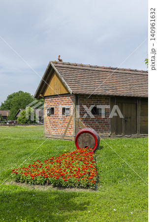 Rustic farm building with creative barrel flower bed in Durdevac Rustic farm building with creative barrel flower bed in Durdevac 140961632