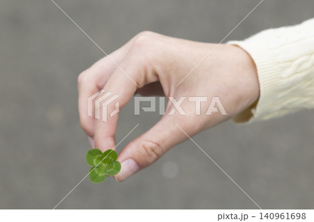 Human hand holding green four leaf clover symbolizing luck and fortune Human hand holding green four leaf clover symbolizing luck and fortune 140961698
