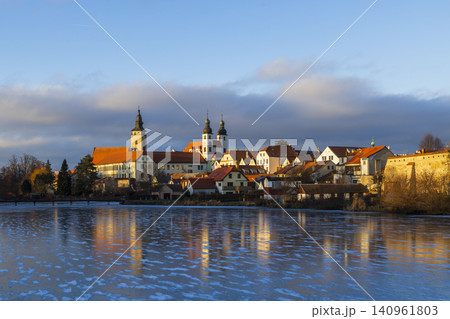 Telc historic town reflecting in frozen lake during sunset Telc historic town reflecting in frozen lake during sunset 140961803