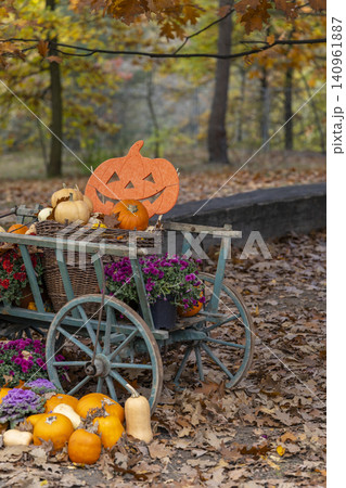Wooden cart displaying autumn harvest and Halloween decoration Wooden cart displaying autumn harvest and Halloween decoration 140961887