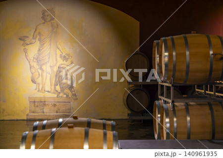 Wine barrels aging in cellar with Dionysus mural 140961935