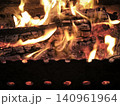 Flames dance over burning logs in a grill 140961964