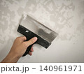 Process of filling a wall with a metal tool in hand 140961971