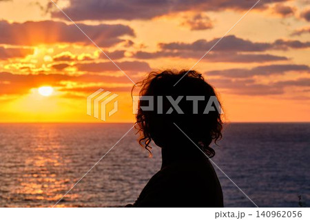 Silhouette of woman looking at sunset over sea Silhouette of woman looking at sunset over sea 140962056